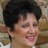 Static pixelated image of a person with short dark hair and light skin, smiling with closed eyes against a blurred background.