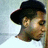 Pixelated static image of a person wearing a dark wide-brimmed hat, light skin tone, and brown hair visible beneath the brim.