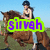 A woman in a black helmet and sleeveless top rides a brown horse against a blue sky, with green grass visible below.