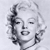 Pixelated grayscale portrait of a woman with closed eyes, styled hair, and a subtle smile against a light background.