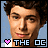 Pixelated static image of a person's face with curly hair, pink heart symbol, and text "THE OC" in blocky font against light blue background.