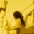 A pixelated image of a dark, curved shape against a yellow background with brown accents.