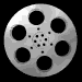 Six circular silver film reels with black perforations arranged in two of three on a black background