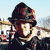 Animated sequence showing a person in firefighter gear with helmet and jacket, transitioning from outdoor setting to dark background.
