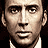 Pixelated close-up of a man's face with light skin, dark eyebrows, and a neutral expression against black background.