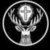 Circular icon with a deer head holding a cross, surrounded by antlers and foliage within a ringed border.