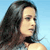 Pixelated static image of a woman's profile with long dark hair against a light blue background, showing partial shoulder and neck area.