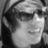 Black-and-white pixelated image of a person wearing sunglasses and a headband, with subtle facial expression variations across four