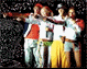 Group of people in two distinct poses against dark speckled background, first with arms extended, second with one person pointing forward.