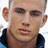 A pixelated image of a person with short hair wearing a dark blue collar, alongside red text on black and gray backgrounds.