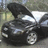 Pixelated static image of a dark-colored sedan with visible headlights and front grille, positioned on a road-like surface.
