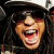 A 2x2 contact sheet of four animated frames showing a person with long dark hair wearing sunglasses and a white cap, each frame displaying different mouth positions and red pixelated text overlays.