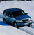 Blue van with dark windows and a teal front section on a light gray background, rendered in low-resolution pixel art style.
