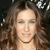 A pixelated close-up of a person with long brown hair, light skin, and closed eyes, set against a dark background with scattered light spots.