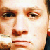 A pixelated close-up of a person's face showing eyes, nose, and mouth with warm brown and beige tones.