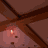 Animated sequence showing a character in an attic-like room with wooden beams and warm lighting, transitioning from standing to crouching while holding a guitar.