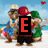 Pixelated cartoon characters on a beach with changing text overlays: E, M, I, L, Y, B294.