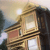 A pixelated image shows a person with long dark hair wearing a light-colored top, holding a golden object with horizontal stripes against a blurred background with light and dark tones.