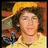 Two side-by-side portraits of a person with curly hair, one wearing a yellow hat and shirt, the other in dark clothing with red sunglasses; below is text reading "He is so sexy!" on white background.