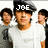 A pixelated image of a person in a white shirt and dark cap with text above the head, surrounded by blurred figures.