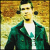 Three distinct poses of a person in front of a brick wall, wearing dark green jacket and white shirt with partial graphic.