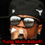 Pixelated image of a person with brown skin, dark hair, and large reflective sunglasses, wearing a dark cap with white accents, mouth open in a shout, red text below.