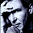 Pixelated grayscale image of a person's face with visible facial features and partial hair, rendered in low-resolution style on black background.