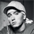 Black-and-white pixelated image of a person wearing a light-colored cap and dark clothing, with a neutral expression and closed eyes.