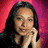 A static pixelated image of a person with long dark hair against a gradient red-pink background, hands clasped near the face.