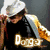 A person wearing a white bucket hat and black shirt with 'Dogg' text, holding a white towel over shoulder against dark background.