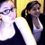 Two women in a , one wearing glasses and a dark sleeveless top over a white shirt, the other with a ponytail and dark jacket over a white shirt, against a yellow background