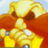 Pixelated character with yellow hair, brown eyes, and orange clothing against a light blue background.