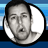Pixelated circular portrait of a person with short dark hair against a blue gradient background, next to blue text reading 'ADAM SANDLER .COM' in blocky letters.