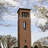 Animated sequence showing a brown brick tower with changing symbols on its facade against a cloudy sky and trees.