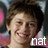 A pixelated close-up of a person with short dark hair smiling, featuring the text 'nat' in white lowercase letters at bottom right.