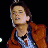 Pixelated static image of a person in an orange jacket and light blue shirt against black background, likely from Back to the Future franchise.