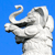Pixelated white elephant head with curled trunk against solid blue background, showing side profile with visible eye and ear details.