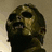 Pixelated image of a distorted face with dark eyes and mouth against a beige background, next to red text on black and a circular symbol.