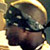 Pixelated static icon of a person's face with dark hair and glasses, set against a bright yellow background with gradient effects.