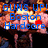 Pixelated image with blue text reading 'GUNS UP! Boston Hardcore' over a blurred background of warm colors and indistinct shapes.