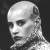 Pixelated grayscale portrait of a bald man with short hair on sides, facing left against dark background.