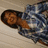 A pixelated image shows a person with brown hair lying on a light-colored surface, wearing a blue and white patterned garment.