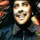 repeated images showing a person in dark clothing with patterned collar, smiling against blurred background