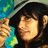 Pixelated image of a person with dark hair wearing a dark hat, holding a small colorful object against a blue-green background.