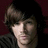 A pixelated image of a person with brown hair against a dark background, accompanied by green text reading "The Bravest," "The Strongest And.......", and "The Hottest.".
