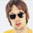Static 48x48 pixel buddy icon showing a person with short brown hair wearing dark sunglasses and a yellow top against a light background.