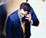 Animated sequence showing a person in a blue suit with a yellow tie holding a phone to their ear, transitioning to a person with brown hair in a black top.
