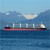 A pixelated static image shows a large cargo ship on calm blue water under a light blue sky with faint clouds.