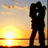 Silhouette of a figure holding a camera against a sunset sky with orange and yellow gradients.