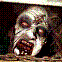 Pixelated grayscale image of a human skull with visible teeth, dark background, and scattered colored pixels.